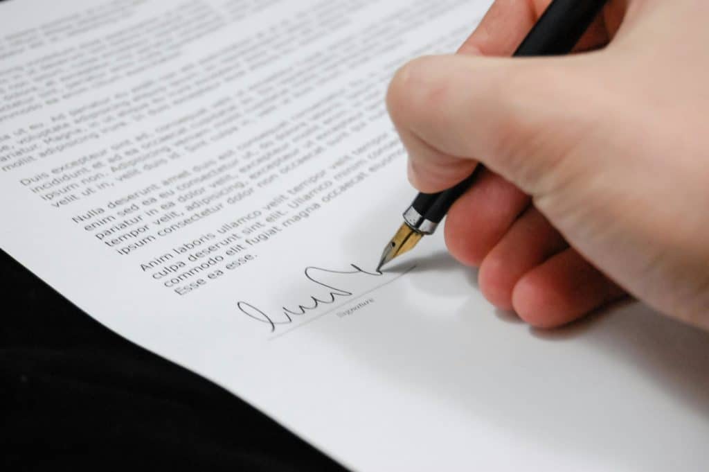 Une personne signe un document Une personne signe un document